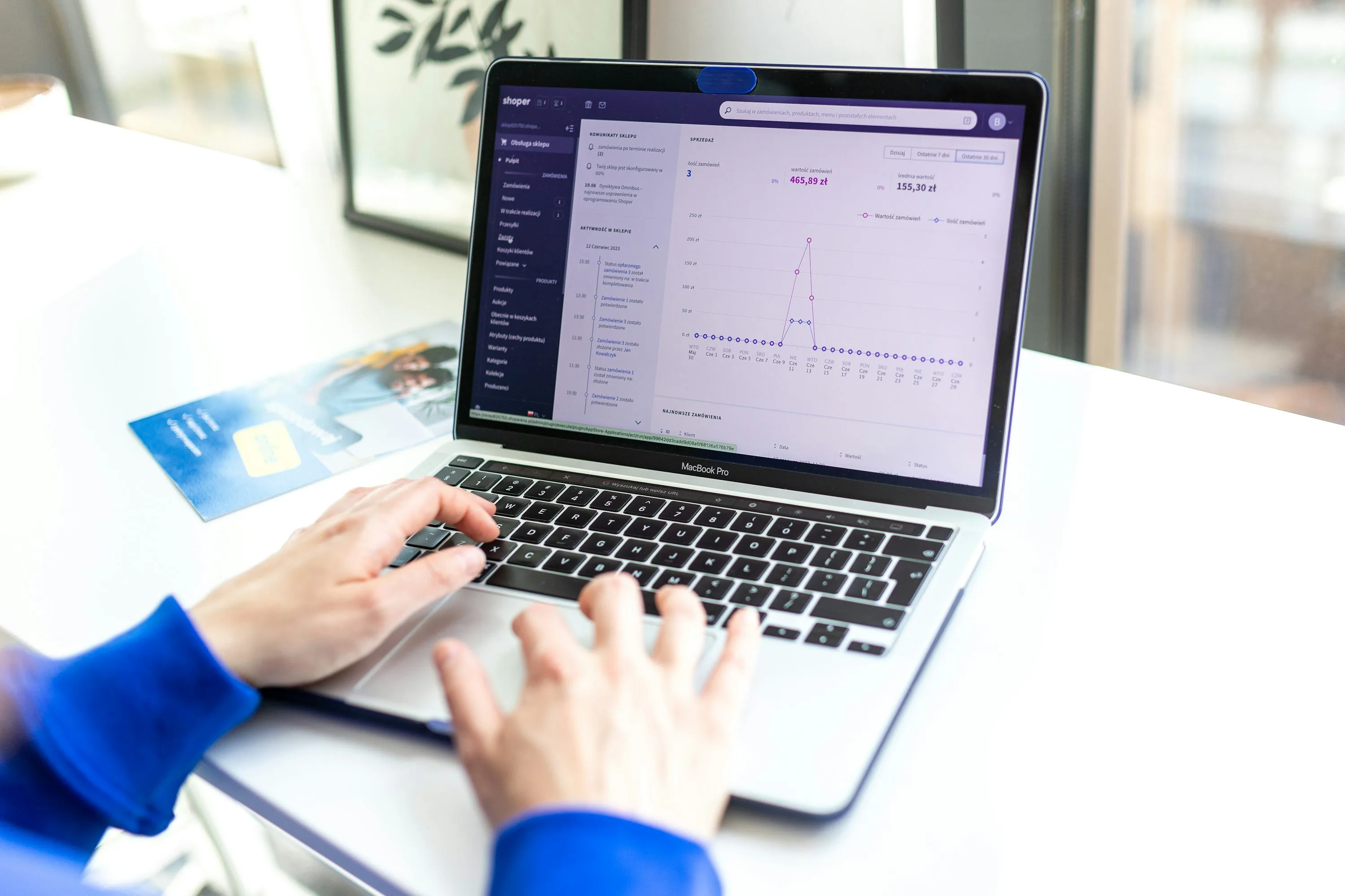 Person typing on a laptop in the Shopify admin, representing a Shopify checkout extensibility migration