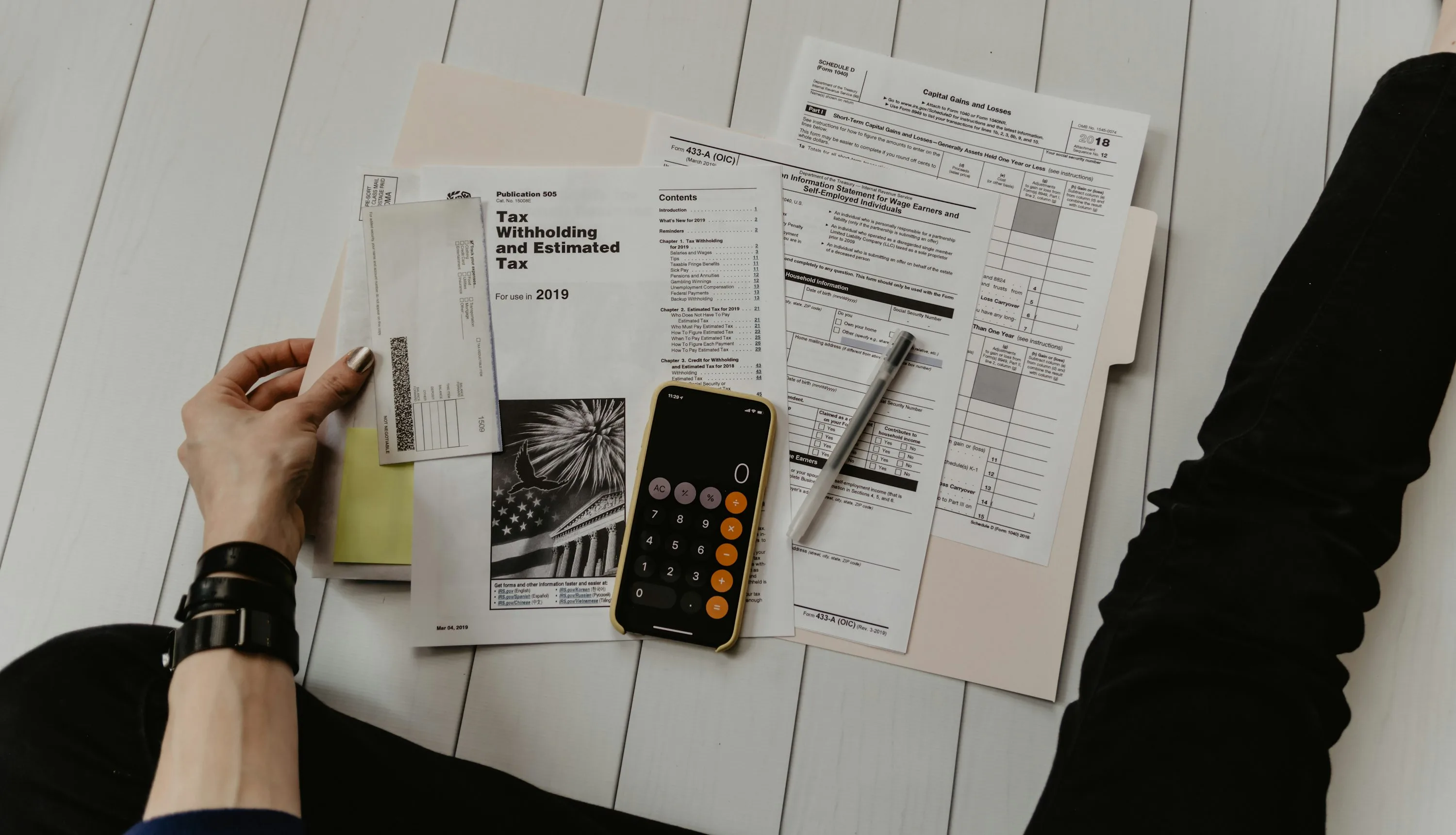 Calculator, forms, and budgeting paperwork on a desk for custom software development cost planning