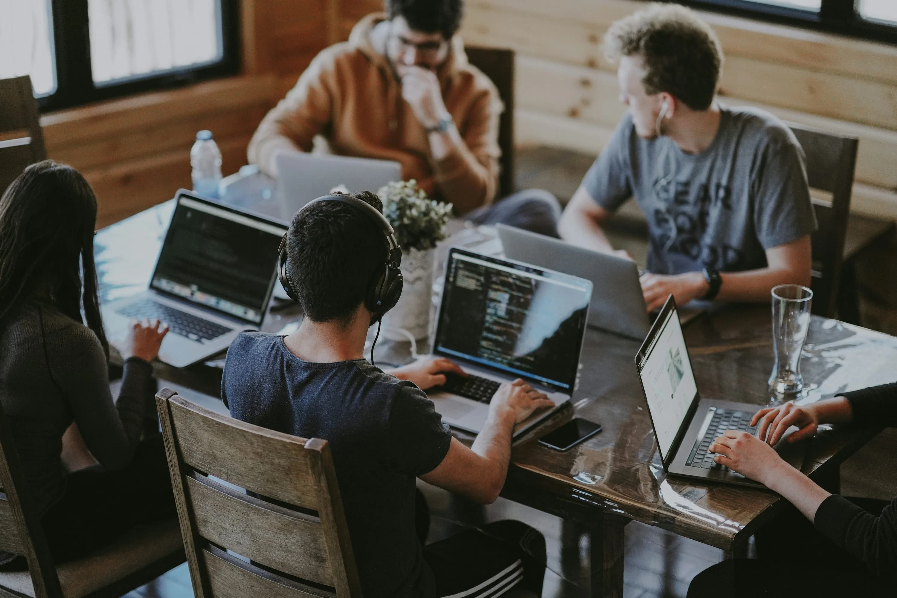 Software developers collaborating around laptops during a project planning session