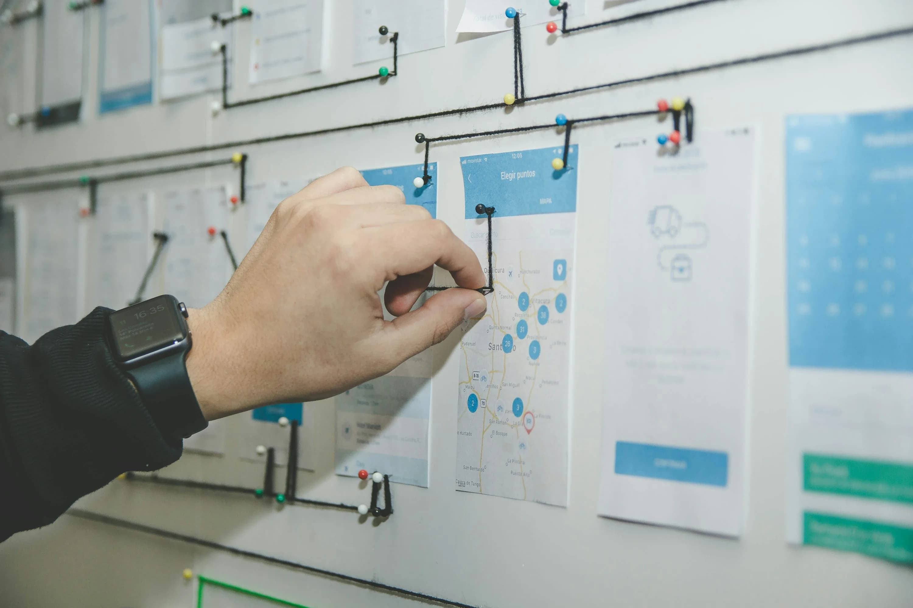 Hand arranging workflow cards on a planning board to represent replacing multiple business tools with one platform