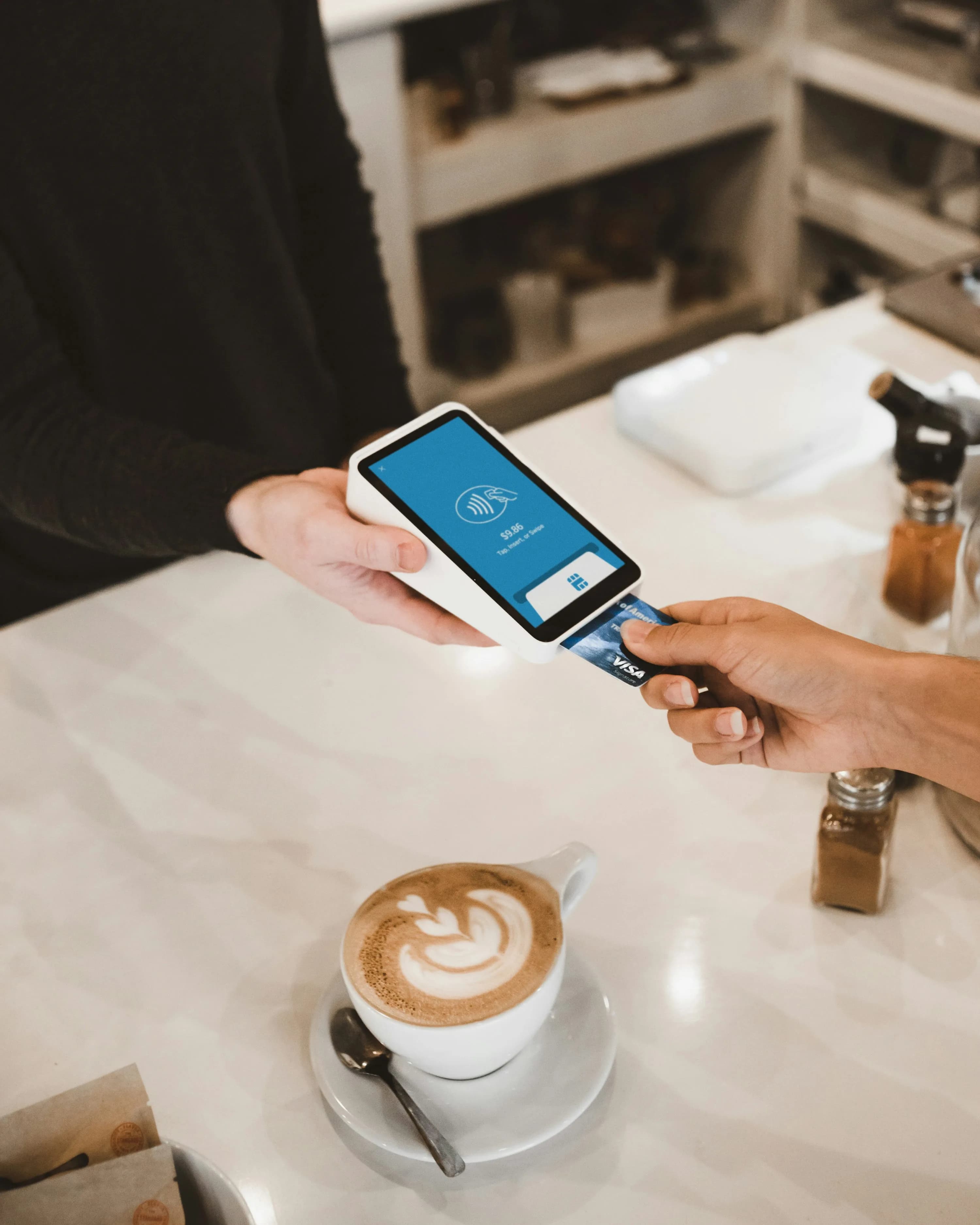 Customer paying with a card terminal in a cafe, representing WooCommerce payment gateways in South Africa